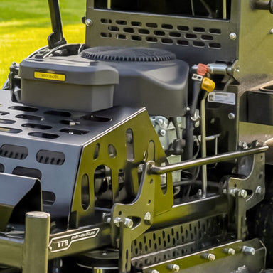 Close-up of the Cobra 32 inch stand on lawn mower engine with visible branding on a grassy background