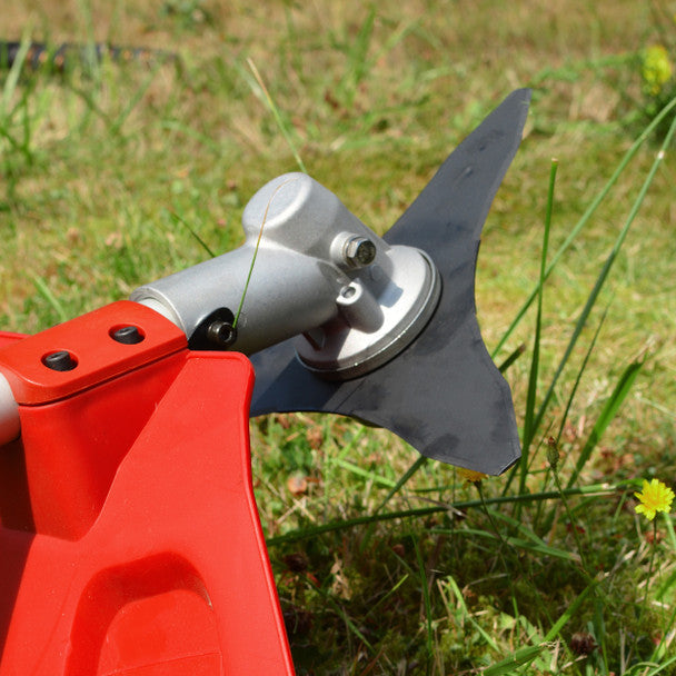 Close-up of a red and silver Cobra BC330CU  against a grassy background