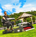 Cobra Fortis Stadium 34' EGO Powered with the trailed seat. Being used in a garden, viewed from the front quarter.