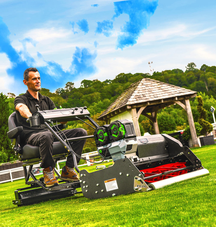 Cobra Fortis Stadium 34' EGO Powered with the trailed seat. Being used in a garden, viewed from the front quarter.