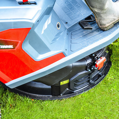 Close-up of a Cobra LTX66HRL lawn mower Mulch discharge on grass with a boot visible.