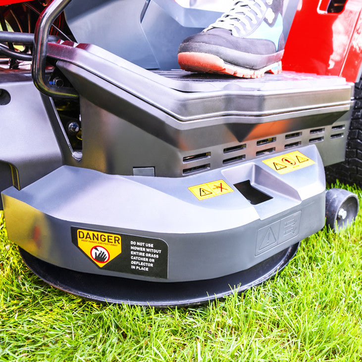 Close up of a Cobra premium ride on  lawn tractor  cutting deck on grass