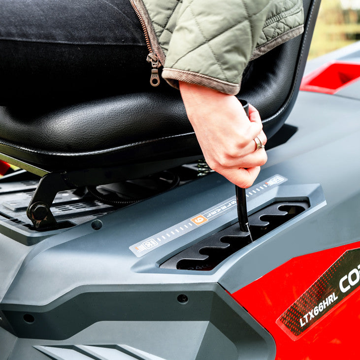 Person adjusting height on a red and gray vehicle seat