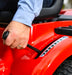 Person adjusting the cutting height on a Cobra lawn tractor with the side lever.