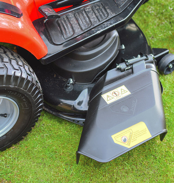 Close-up of a cobra ride on lawn tractorside discharge shoot on grass with a visible brand logo.