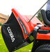 Red Cobra lawn tractor on a grassy area, emptying grass box from seat. Against a blurred background