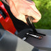 Hand using the throttle control on a cobra premium ride on lawn tractor, against a grassy background