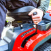 Hand operating the height of cu control lever on the left hand side of the Cobra ride on lawn tractor 
