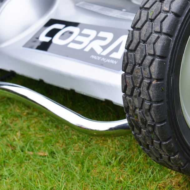 Close-up of a Cobra lawn mower front bar on grass